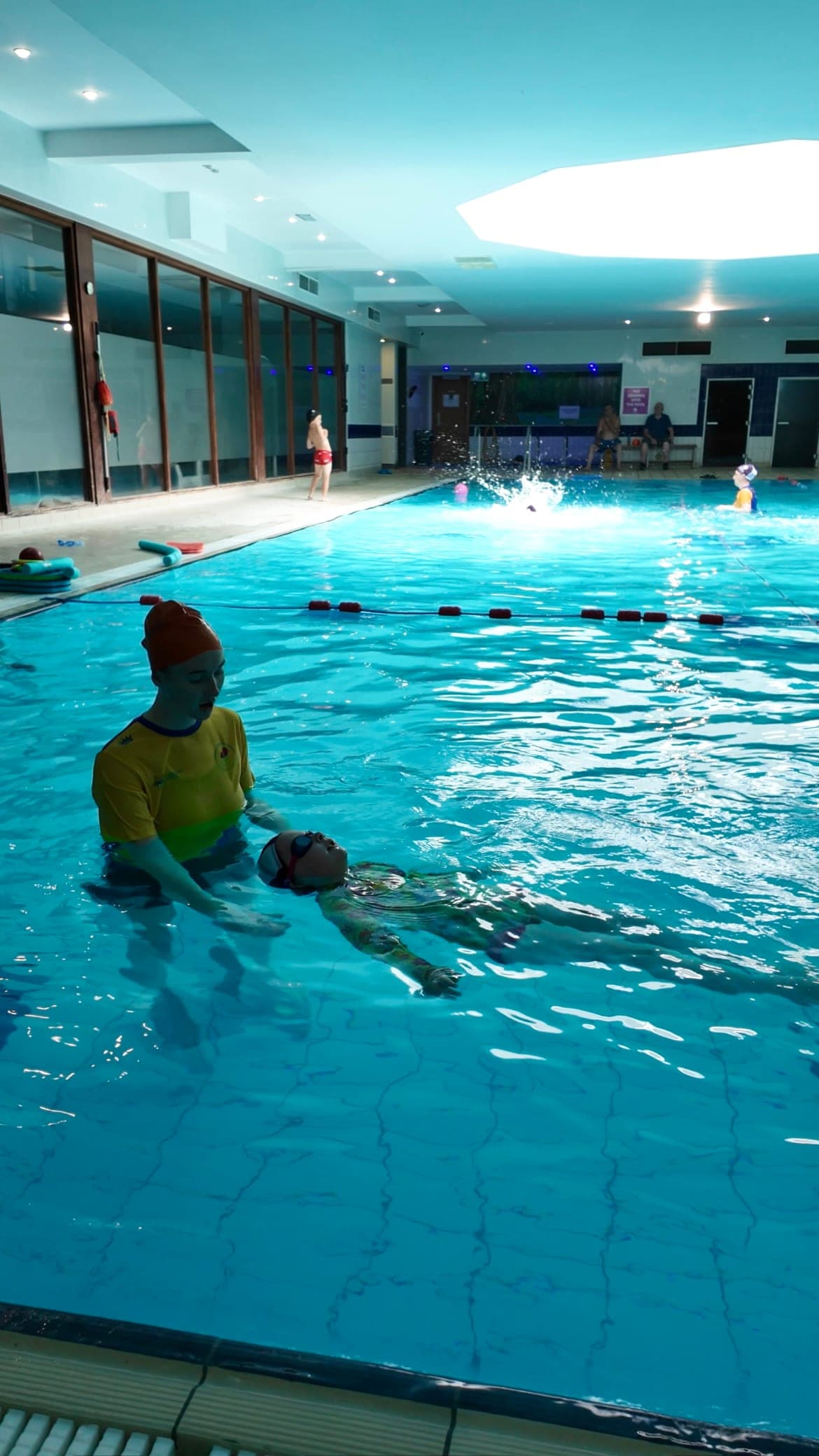 A swim teacher supporting a child across the width of the Talbot Hotel pool