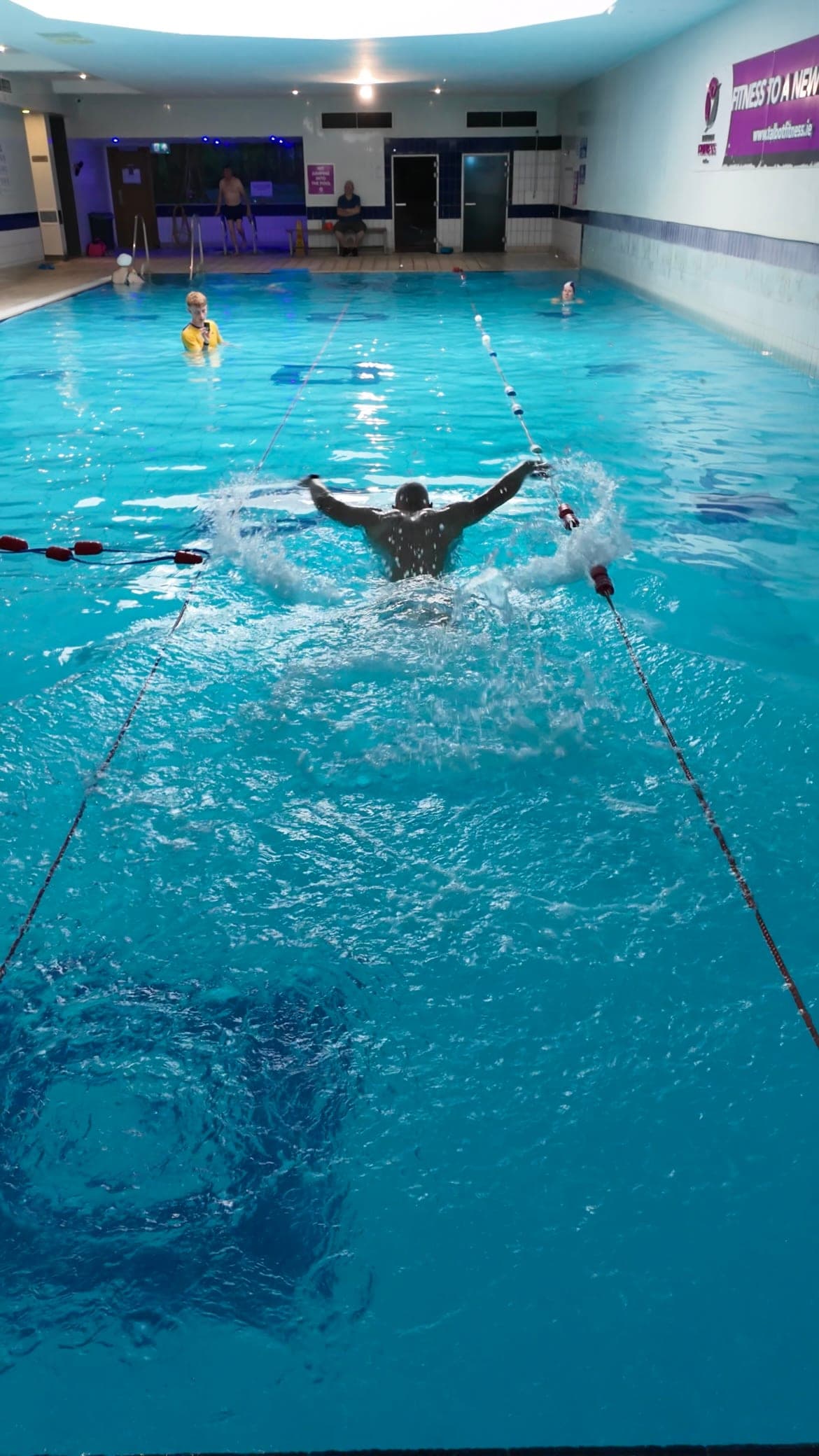 A swimmer powering through a butterfly stroke across the pool